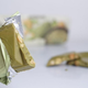 Hand holding matcha candy bar with nuts